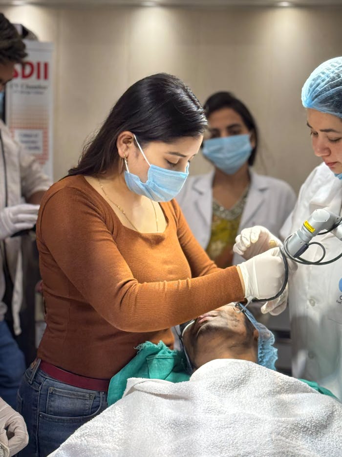Medical professionals perform a cosmetic treatment in a Delhi clinic, focusing on patient care.