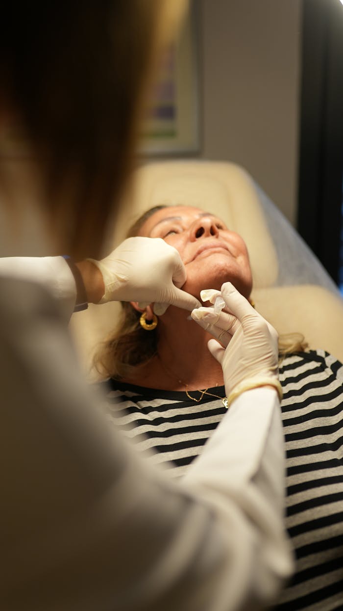 A patient receiving cosmetic treatment in a clinic setting, highlighting professional skincare procedures.